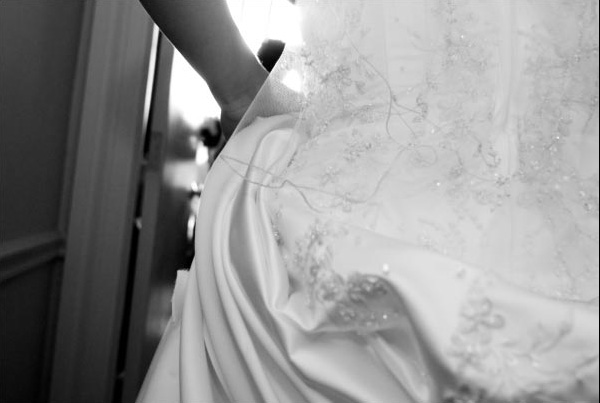 Bride holds dress.