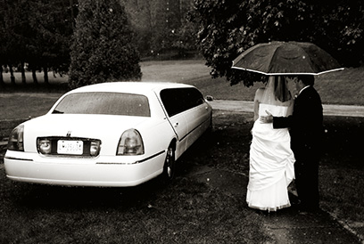 The wedding photographer captured this photograph of the bride being led to the limo by her father.