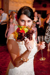 journalistic photograph of a happy bride just before tossing her flower boquet